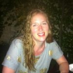 woman with long hair and blue short sleeve shirt smiling
