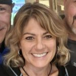 woman with short blonde hair and black shirt smiling