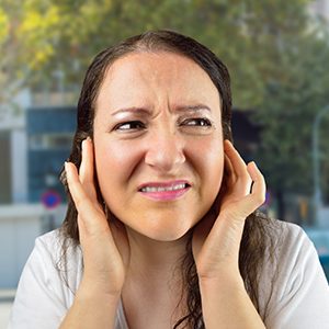 A woman covering her ears with her hands