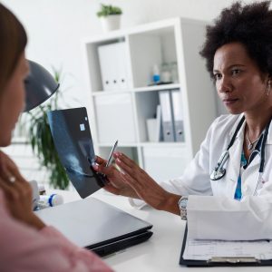 Doctor talking with patient at desk in medical office