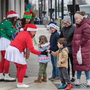 adults and kids on sidewalk during holiday event