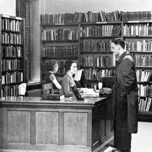 black and white photo of people in library