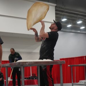 man spinning pizza dough