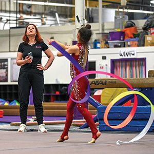 woman coaching girl in gymnastics