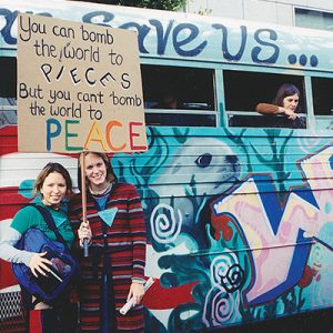 two women holding peace sign by bus