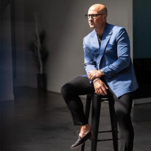 man in blue suit sits on seat
