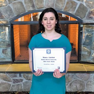 woman with blue dress holds certificate and smiles
