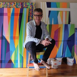 man sitting with colorful artwork