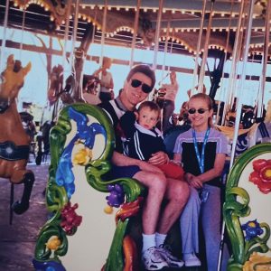 man with two children on merry go round