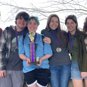 teens holding trophy and medals