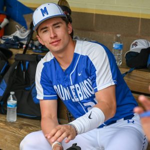 teen baseball player in dugout