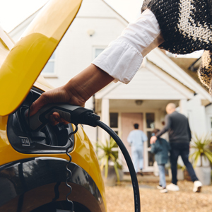 a person plugging in a car charger into their home