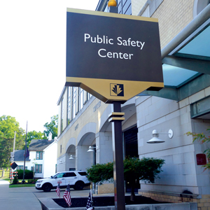 black and golf sign that says public safety center in front of a building
