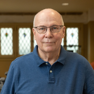 Man with glasses in a blue polo shirt standing in the Mount Lebanon Historical Society.