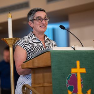 woman with glasses at church podium speaking