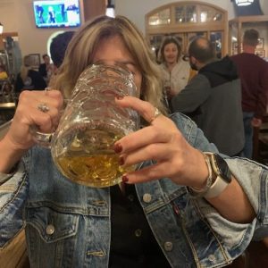 women drinking large mug of beer in a bar
