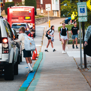 sidewalk with kids, car and bus