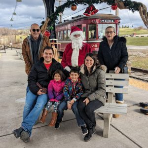 trolley behind a group photo of a family with Santa