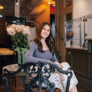 woman sitting in cafe smiling with flowers