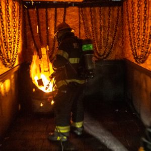 A firefighter putting out a fire in a training facility