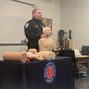 A man holding a CPR manikin.
