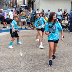 Children dancing with blue shirts on.