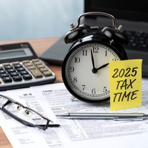2025 TAX TIME note is on the alarm clock