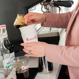An espresso shot being poured into a cup that has the BR3WED logo on it
