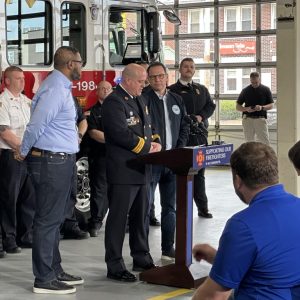 Fire Chief addresses crowd in front of a fire truck