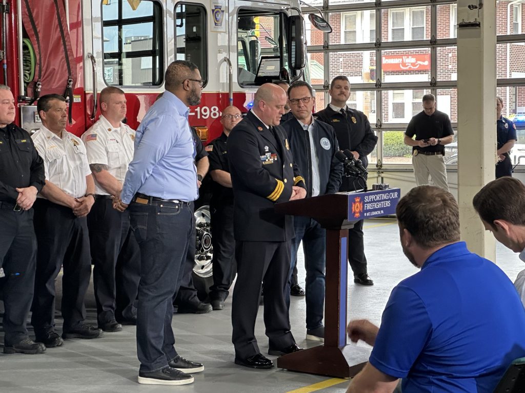 Fire Chief addresses crowd in front of a fire truck