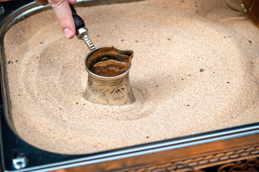 a coffee pot in sand making turkish coffee