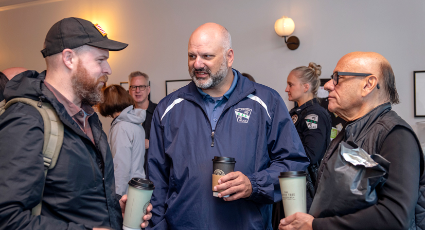 several men talking in a coffee shop wearing police jackets
