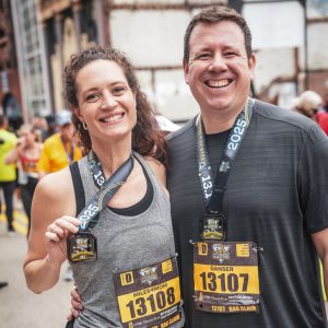 man and woman smile for photo at marathon