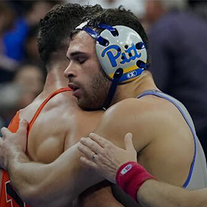 Two male wrestlers embrace after a match at the NCAA Wrestling Championships.