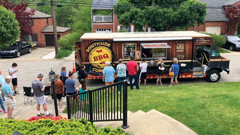 Southside BBQ food truck sitting in a neighborhood with a long line of people waiting to get food.