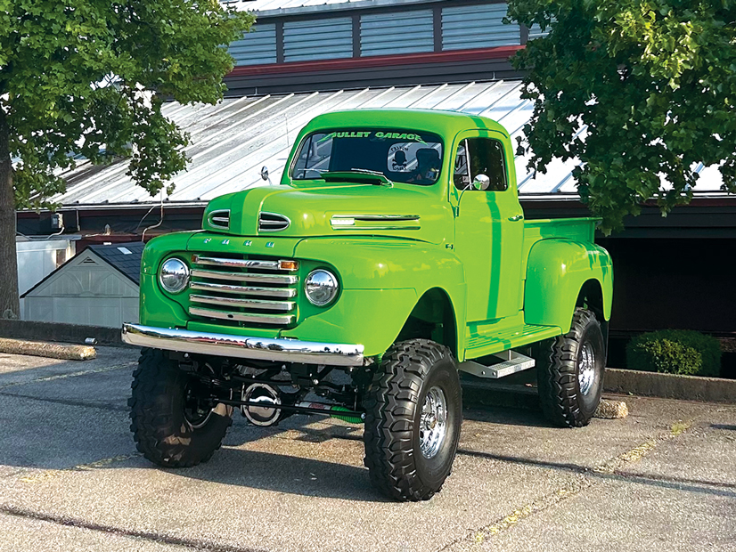 A lime green 1948 ford truck that has been lifted and has large tires on it
