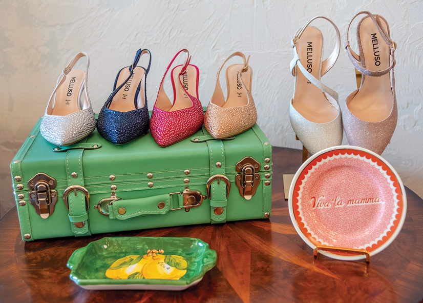 colorful high heel shoes on a green brief case and pink plate on table