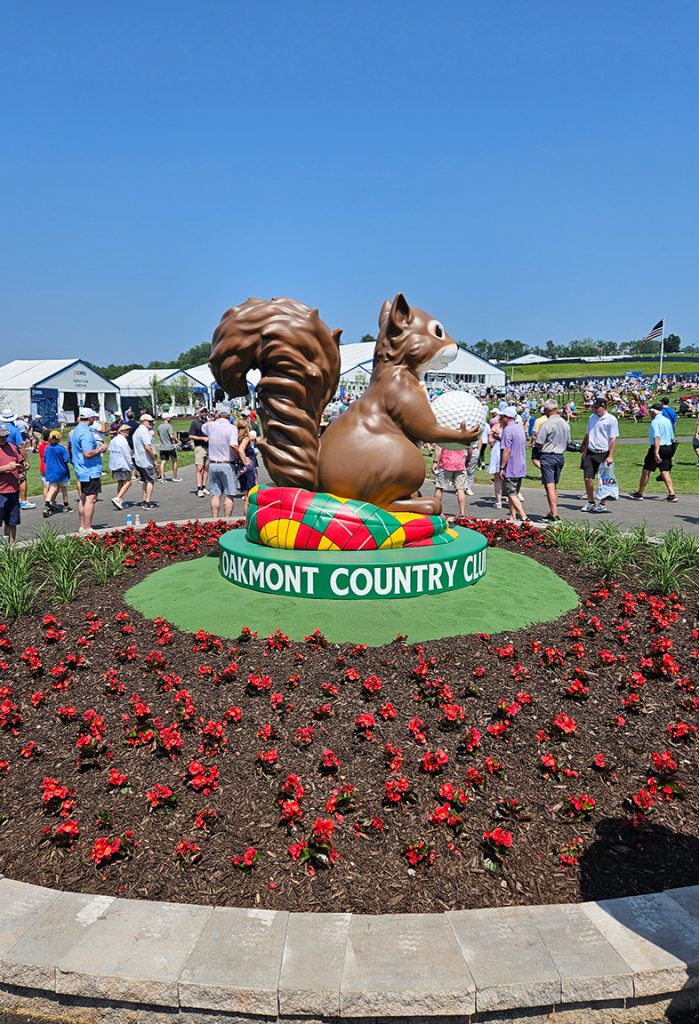 Oakmont Country Club squirrel sculpture on golf course with red flowers