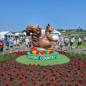 Oakmont Country Club squirrel sculpture on golf course with red flowers
