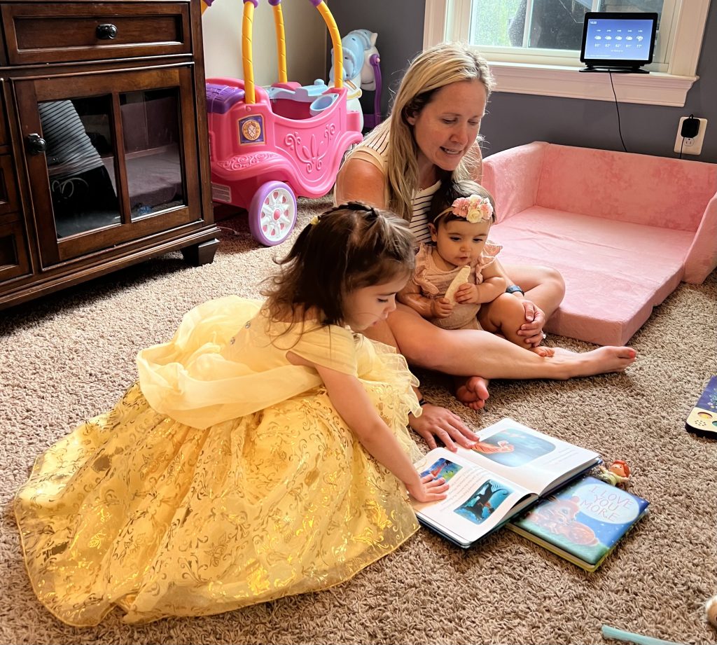 A woman reading to two young girls