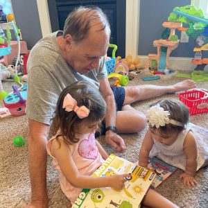 A man reading a book with two toddlers