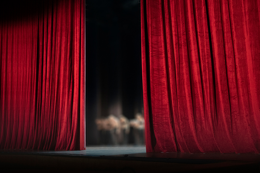 red curtain opening on a stage