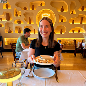 woman in black t shirt holding plate of hummus in resturant