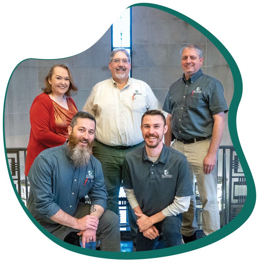 Four men and one woman posing for a group picture smiling.