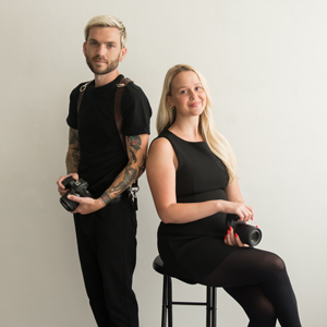 man and woman in black clothing holding cameras