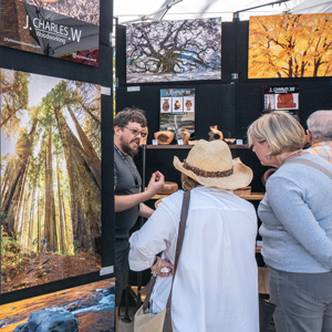 artist and patrons looking at artwork at a fair