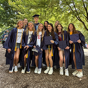 group photo of graduating high schoolers in navy gowns