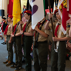 scouts in uniform hold flags and look forward