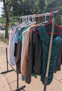 rack of clothing on sidewalk
