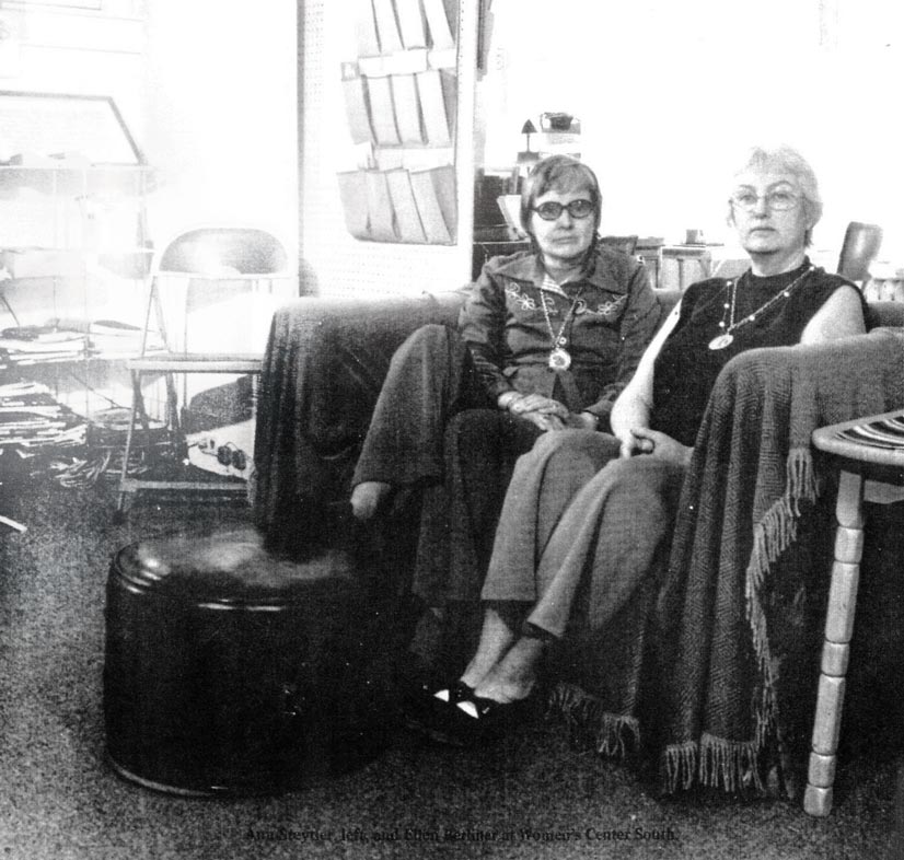 A black and white photo of two women in the 1970's sitting on a large chair.